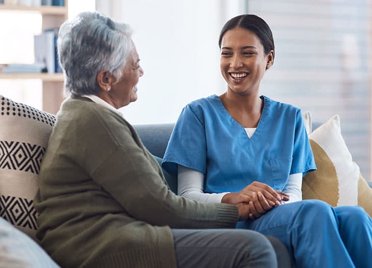 Nurse talking with a smiling woman.