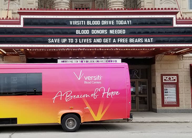 A Versiti mobile bus outside a Chicago movie theater that is hosting a blood drive.
